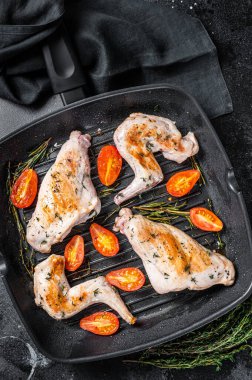 Tavada kekik ile kavrulmuş tavşan bacağı. Siyah arka plan. Üst görünüm