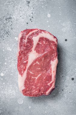 Çiğ kaburga bifteği, kasap tahtasının üzerinde mermer et. Gri arka plan. Üst görünüm