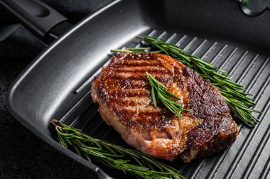 Kızarmış kaburga bifteği, ızgara tavada pirzola eti. Siyah arka plan. Üst Manzara. Boşluğu kopyala