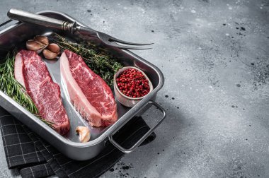 Çiğ sığır filetosu ya da tepside otlu biftek. Gri arka plan. Üst Manzara. Boşluğu kopyala