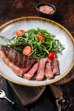 Biftekli ızgara sığır eti ve sebze salatası. Karanlık arka plan. Üst görünüm