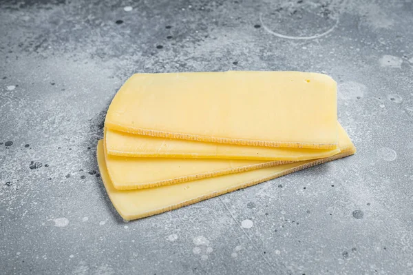 Raclette rebanadas de queso suizo sin cocer. Fondo gris. Vista superior — Foto de Stock