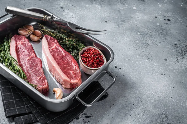 Çiğ sığır filetosu ya da tepside otlu biftek. Gri arka plan. Üst Manzara. Boşluğu kopyala