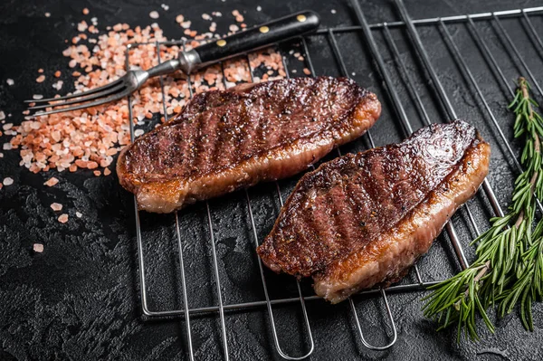 BBQ Grilovaný krkovička nebo hovězí steak z hovězí svíčkové, smažené maso na grilu. Černé pozadí. Horní pohled — Stock fotografie