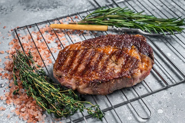 Barbekü ızgara kaburga bifteği, ızgarada otlu biftek eti. Gri arka plan. en üstteki görünüm — Stok fotoğraf