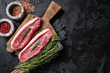 Çiğ sığır etli biftek ya da kasap panosunun üstünde sığır filetosu. Siyah arka plan. Üst Manzara. Boşluğu kopyala