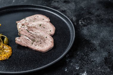 Bir tabakta haşlanmış dil dilimleri. Siyah arka plan. Üst Manzara. Boşluğu kopyala