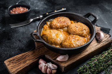 Tavada domates soslu ton balıklı balık köftesi. Siyah arka plan. Üst görünüm