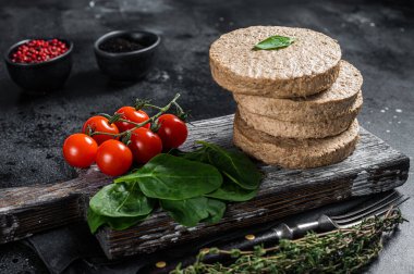 Vejetaryen bitkisel köfteler, çiğ vejetaryen pirzolalar ve şifalı otlar. Siyah arka plan. Üst görünüm