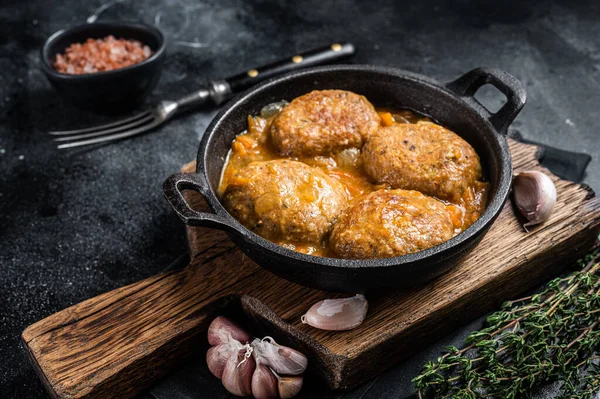 Tavada domates soslu ton balıklı balık köftesi. Siyah arka plan. Üst görünüm