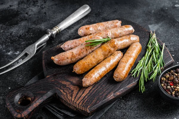 Smażone kiełbaski Bratwurst lub Hot Dogs na drewnianej desce. Czarne tło. Widok z góry — Zdjęcie stockowe