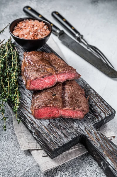 Kavrulmuş Omuz Üstü Bıçak ya da ahşap tahtada düz demir et bifteği. Beyaz arka plan. Üst Görünüm