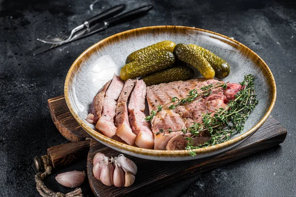 Вечеря на барбекю - стейки зі свинини з м'яса шиї в тарілці з готами. Чорний фон. Вид зверху — стокове фото
