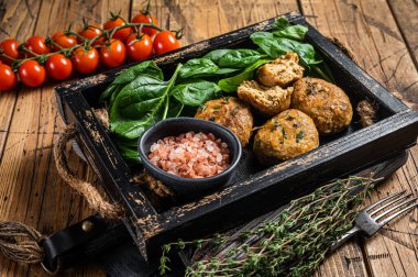 Balık köftesi mi yoksa ıspanaklı ve şifalı otlu balık köftesi mi? Ahşap arka plan. Üst görünüm