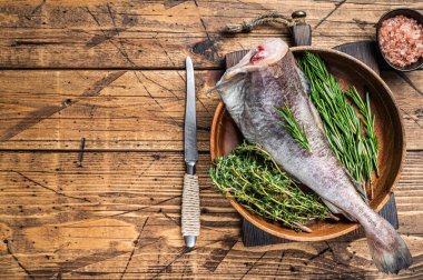 Çiğ morina ya da ahşap tabakta otlu morina balığı. Ahşap arka plan. Üst Manzara. Boşluğu kopyala