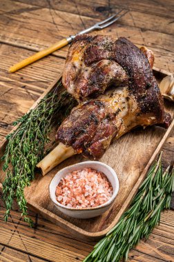 Ahşap bir tepside kızarmış keçi budu eti. Ahşap arka plan. Üst görünüm