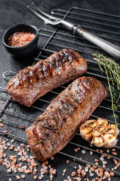 BBQ grilled Lamb tenderloin fillet meat on grill, mutton loin steak. Black background. Top view — 图库照片