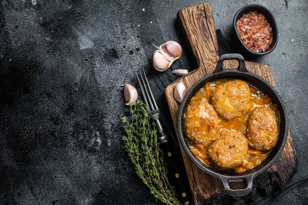 Tavada domates soslu ton balıklı balık köftesi. Siyah arka plan. Üst Manzara. Boşluğu kopyala