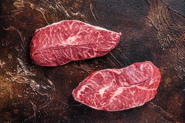 Raw Top Blade или плоские стейки из говяжьего мяса на мясном столе. Темный фон. Вид сверху — стоковое фото