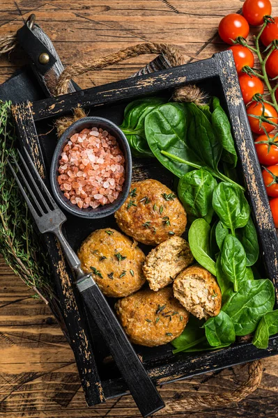 Balık köftesi mi yoksa ıspanaklı ve şifalı otlu balık köftesi mi? Ahşap arka plan. Üst görünüm