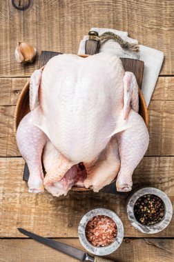 Organik tavuk, ahşap tabakta çiğ kümes hayvanları. Ahşap arka plan. Üst görünüm