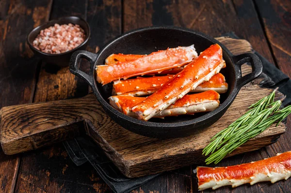 Alaskan King Crab legs Phalanx in a pan with herbs. Dark wooden background. Top view — Stock Photo, Image