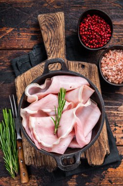 Tavada dilimlenmiş jambon. Koyu ahşap arka plan. Üst görünüm