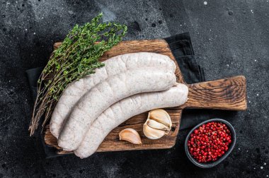 Tahta üzerinde çiğ Münih beyaz sosisi sosisi. Siyah arka plan. Üst görünüm