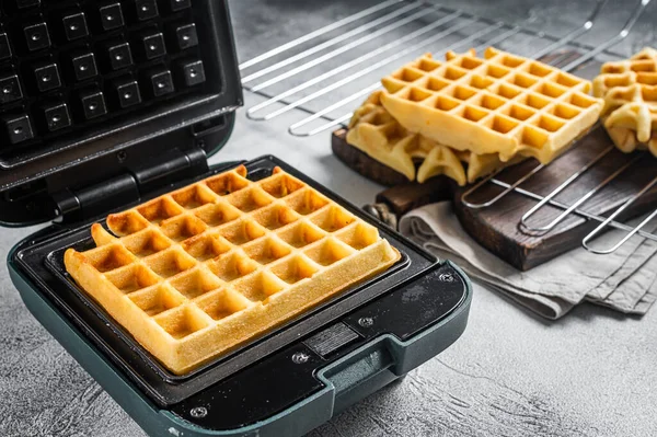 Cooking of fresh waffles in waffle maker. White background. Top view — Stock Photo, Image