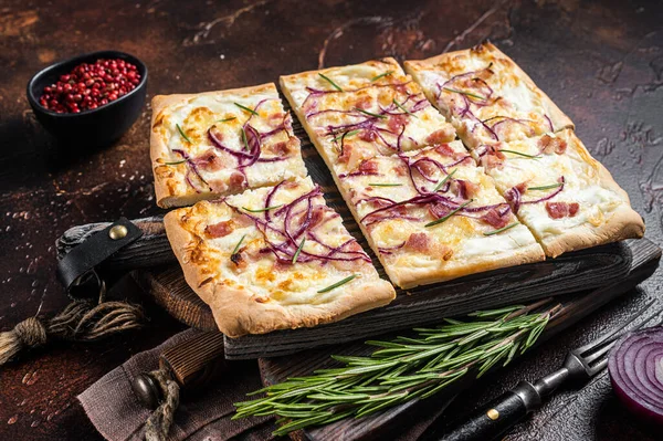 Krem peynirli, pastırmalı ve soğanlı Fransız tarte flambee. Alsace bölgesinden Flammkuchen. Karanlık arka plan. Üst görünüm