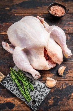 Bütün tavuk, et satırıyla kasap masasında çiğ kümes hayvanları. Karanlık ahşap arka plan. Üst görünüm