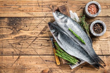 Tahta kesme tahtasının üzerinde biberiyeli taze deniz ürünü. Ahşap arka plan. Üst Manzara. Boşluğu kopyala