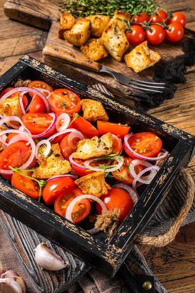 Traditionele Italiaanse Panzanella salade met tomaten, ui en brood Croutons in houten dienblad. Houten achtergrond. Bovenaanzicht — Stockfoto