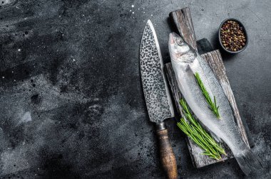 Tahtada pişmeye hazır taze çiğ deniz kabuğu ya da levrek balığı. Siyah arka plan. Üst Manzara. Boşluğu kopyala