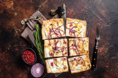 Krem peynirli, pastırmalı ve soğanlı Fransız tarte flambee. Alsace bölgesinden Flammkuchen. Karanlık arka plan. Üst görünüm