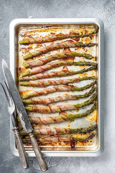 Sparris insvept i Bacon på en grillbricka. Vit bakgrund. Ovanifrån — Stockfoto