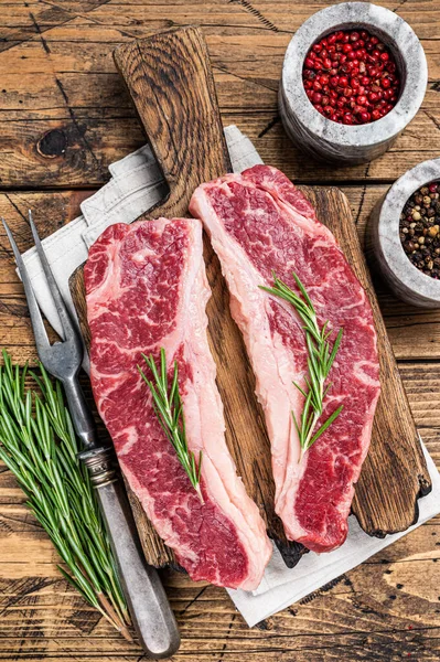 Prime Black Angus bifteği, Raw Striploin veya New York. Ahşap arka plan. Üst görünüm
