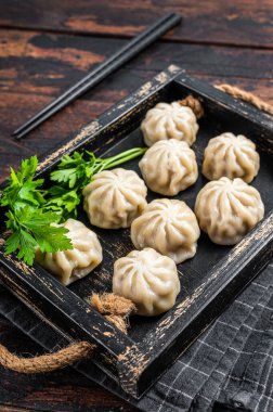 Tahta tepside otlu Momo hamur tatlısı. Karanlık ahşap arka plan. Üst görünüm