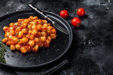 Domates soslu İtalyan Gnocchi patatesli makarna. Siyah arka plan. Üst Manzara. Boşluğu kopyala