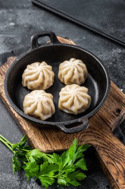 Tavaya doldurulmuş etli börek ve şifalı otlar. Siyah arka plan. Üst görünüm