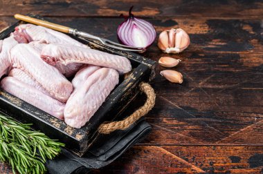 Taze çiğ ördek ve tepside tavuk kanadı. Koyu ahşap arka plan. Üst Manzara. Boşluğu kopyala