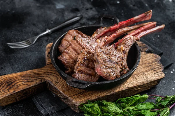 BBQ Gegrilltes Lamm hackt Steaks in einer Pfanne. Schwarzer Hintergrund. Ansicht von oben — Stockfoto