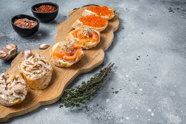 Somon afumat și caviar roșu toastează aperitiv cu brânză cremă. Fundal gri. Privire de sus. Copiați spațiul — Fotografie, imagine de stoc