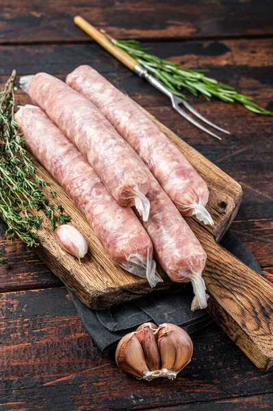 Bockwurst Raw sausages with pork meat on a wooden board. Dark Wooden background. Top view — Stock Photo, Image