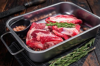 Biberiyeli çelik tepside çiğ biftek. Ahşap arka plan. Üst görünüm