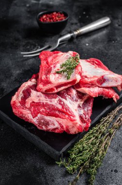 Dana eti, pirzola, mermer panoda çiğ pirzola. Siyah arka plan. Üst görünüm