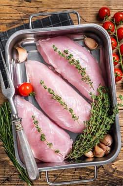 Çiğ hindi bifteği, kekik ve biberiyeli göğüs filetosu. Ahşap arka plan. Üst görünüm