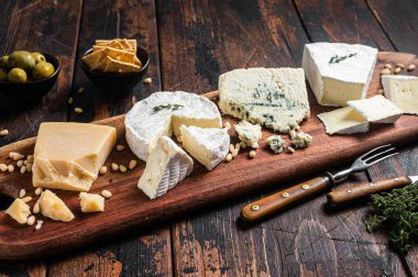 Peynir tabağı, camembert, brie, Gorgonzola, parmesan, zeytin, fındık ve kraker. Ahşap arka plan. Üst görünüm