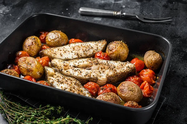 Roasted halibut fish steaks with tomato and potato. Black background. Top view — Stock Photo, Image