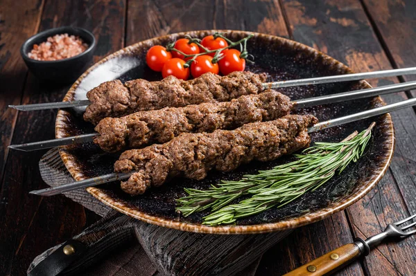 Grillowany kebab Shish na szaszłykach z mielonej wołowiny, Lula kebab. Drewniane tło. Widok z góry — Zdjęcie stockowe